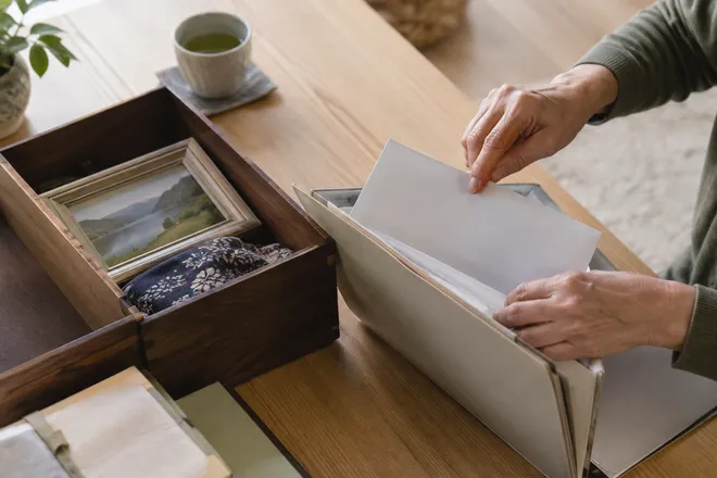 書類と思い出の品を分ける手元（生成画像）
